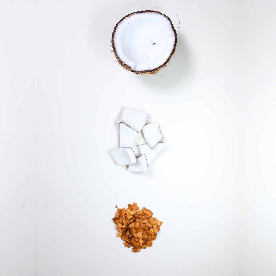 Metade de um coco in natura no topo, pedaços de coco ao meio e chips de coco crocante embaixo.